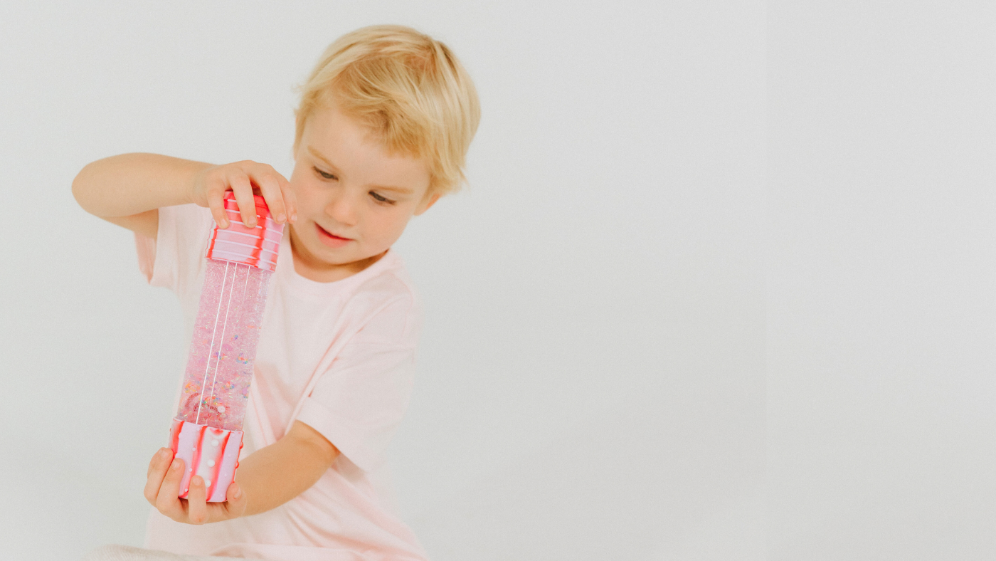 Girl playing with pink sensory bottle