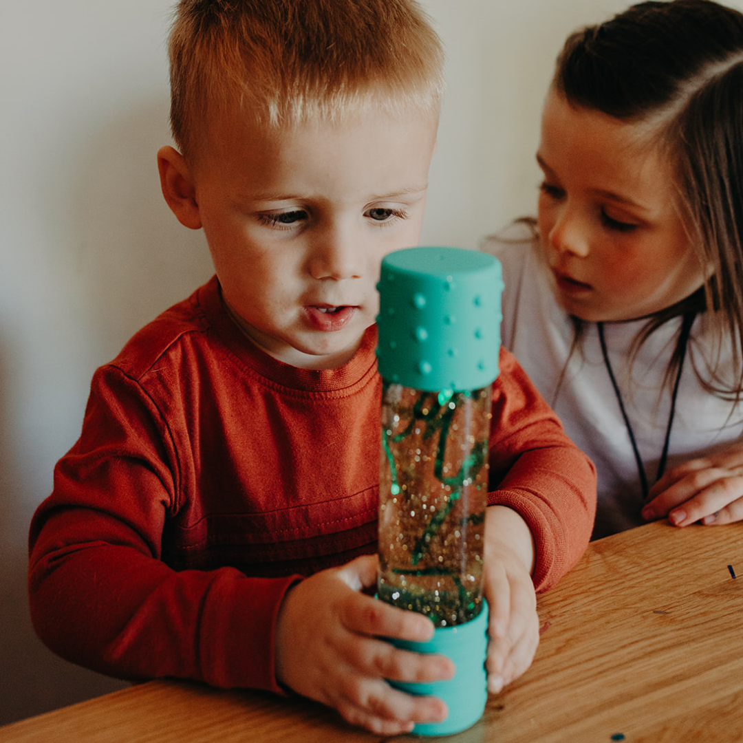 Boy holding mint green calm down bottle