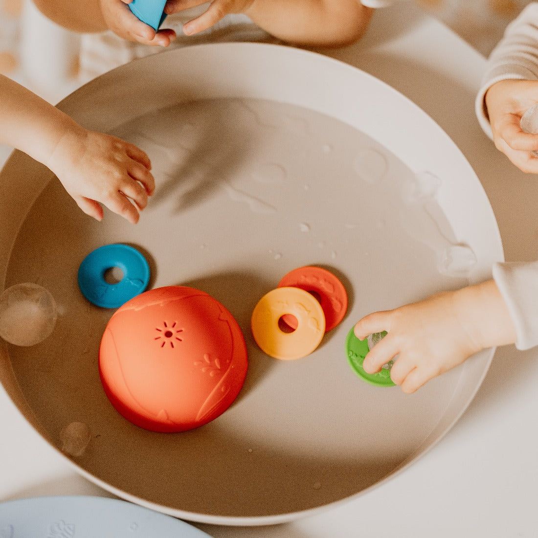 Little hands playing with the Ocean Stacking Cups in Bright