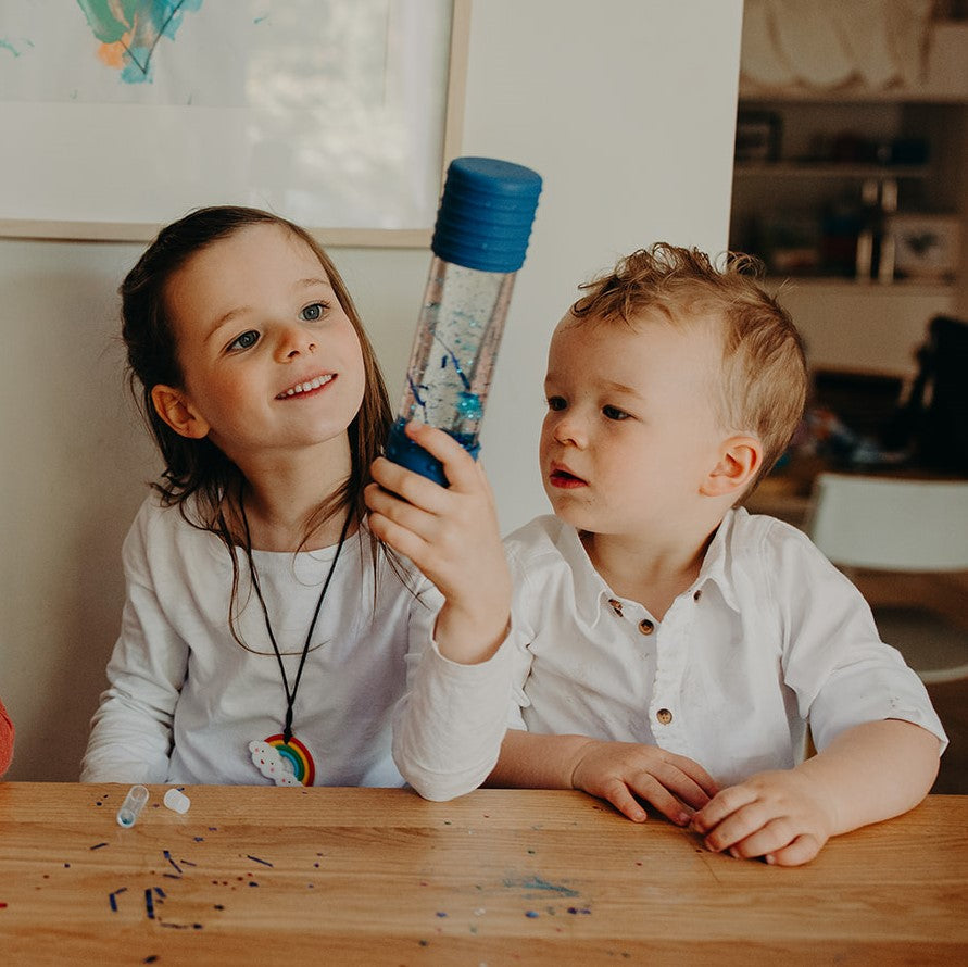 Kids looking at sensory bottle