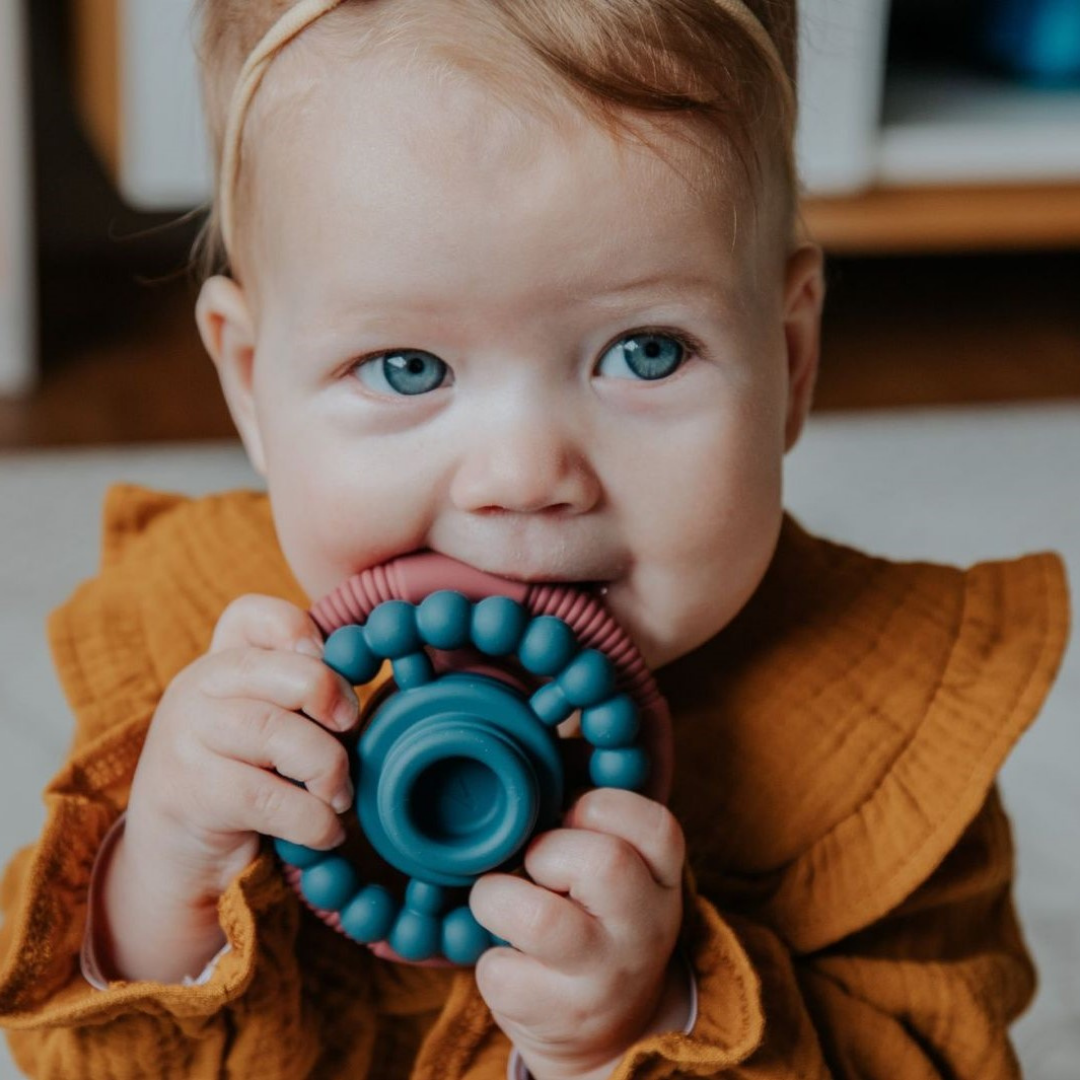 Girl teething on stacker rings