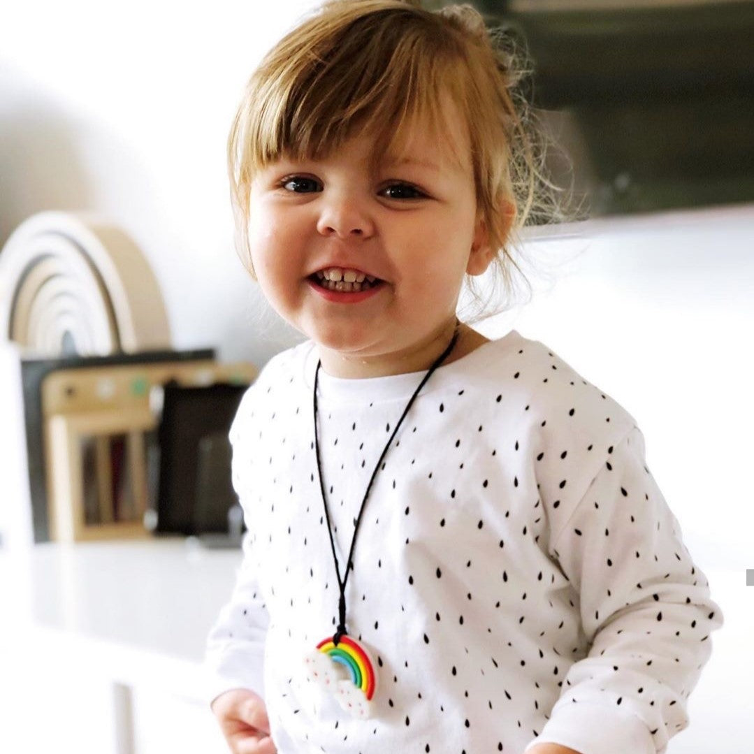 Girl wearing rainbow pendant.