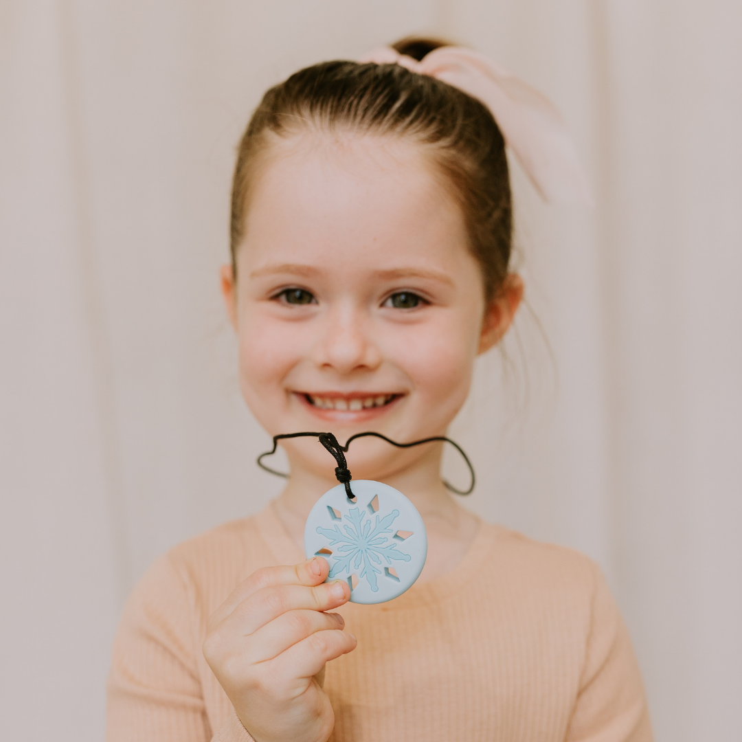 Girl holding a snowflake pendant