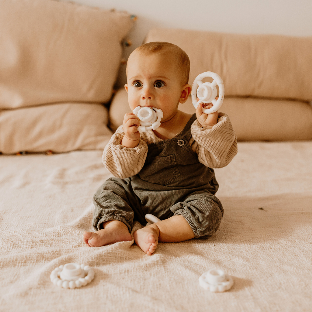 Baby boy chewing on silicone stacker